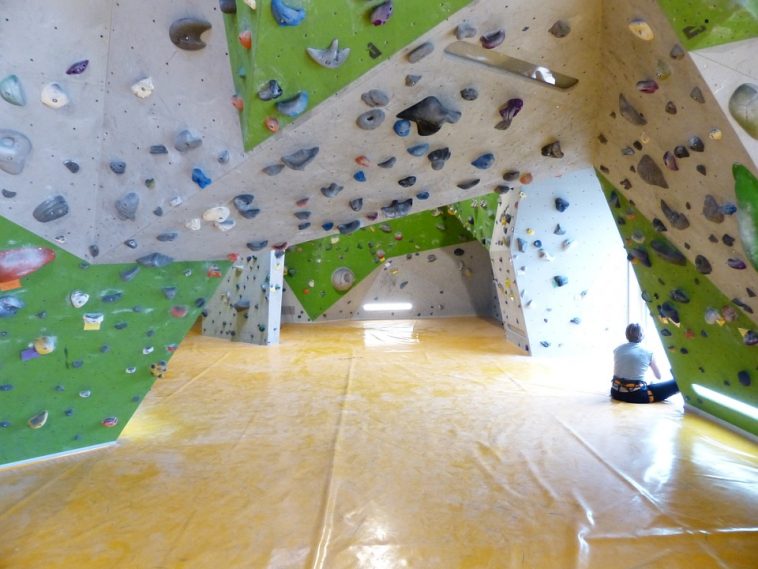 Sala de un rocódromo lleno de presas y colchonetas