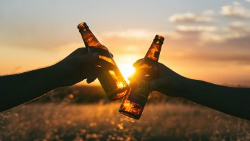 Brindando con dos quintos de cerveza al atardecer