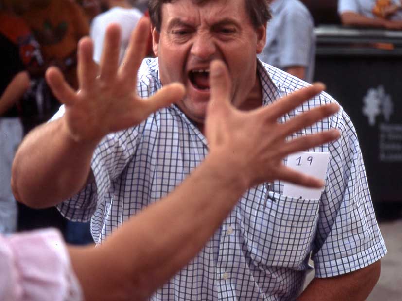 Un hombre en plena acción del juego de la morra, disfrutando de juegos tradicionales