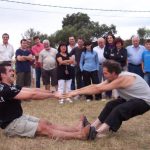 Juegos de fuerza, como el tiro del palo, en la foto se ve a dos hombres practicando este juego
