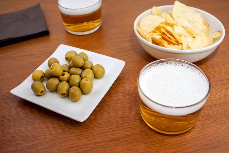 Penalti de cerveza entre olivas y patatas