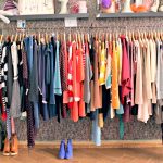 Un perchero lleno de ropa en una tienda vintage